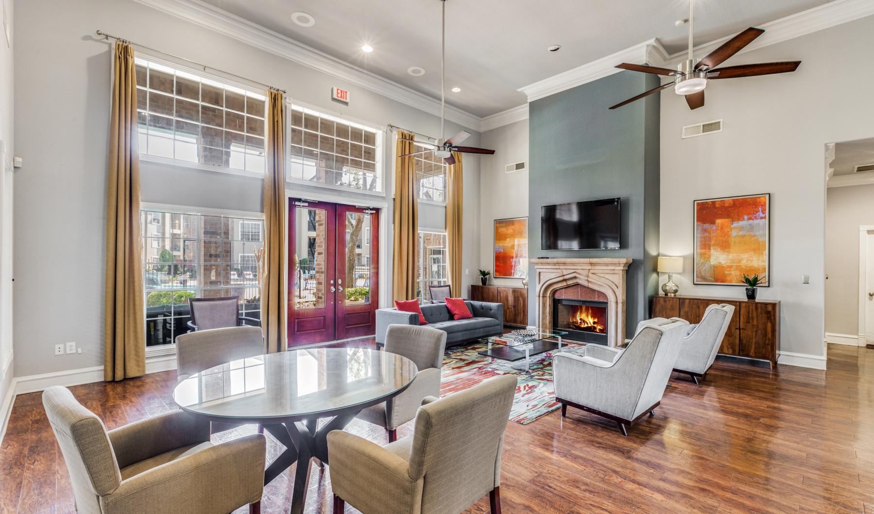 a clubroom with tables, chairs and a fireplace