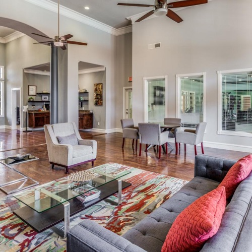 a clubroom with a couch, chairs and tables